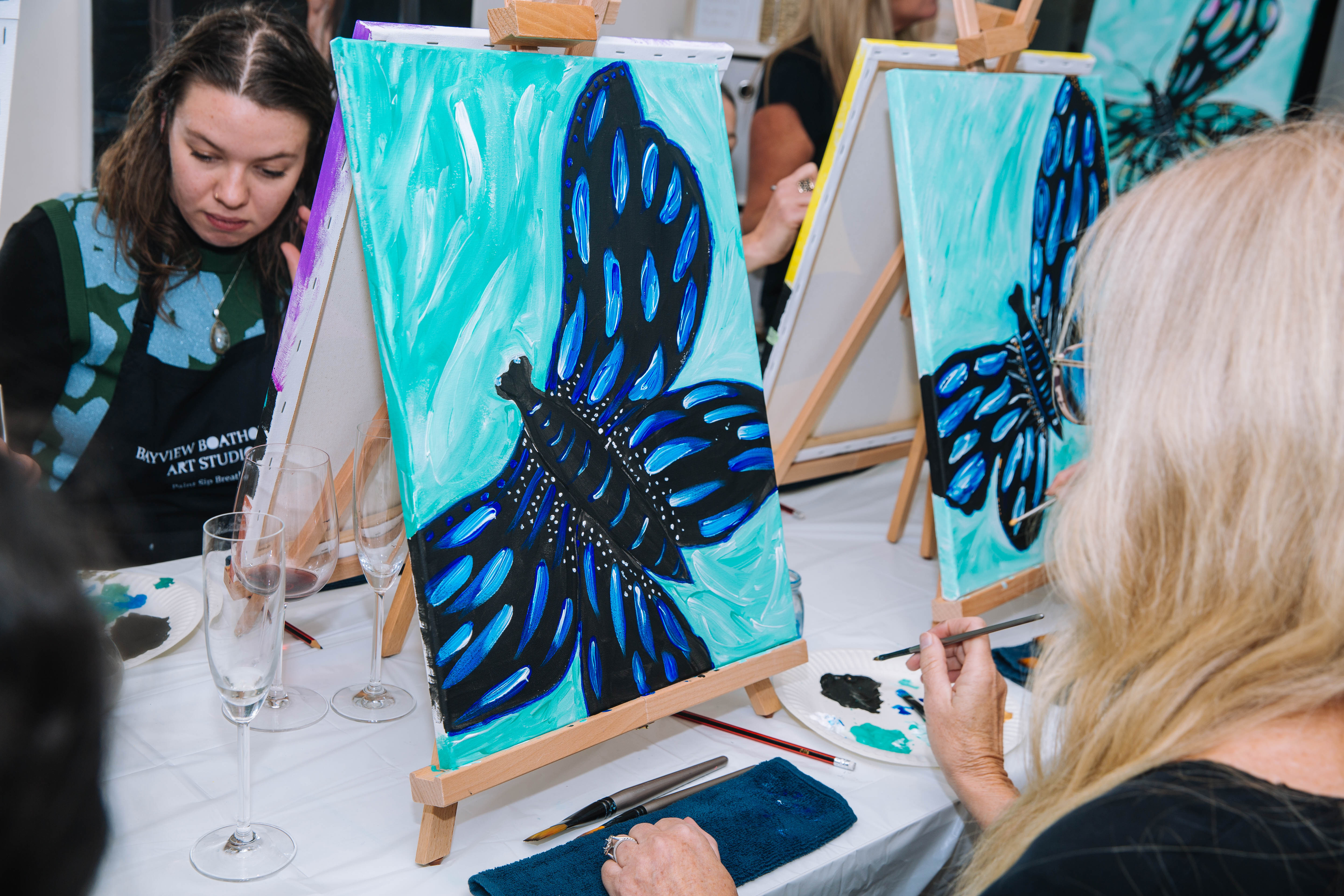 Group of people painting on easels